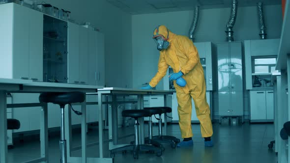 Worker in a Hazmat Suit Is Cleaning Surfaces in the Laboratory