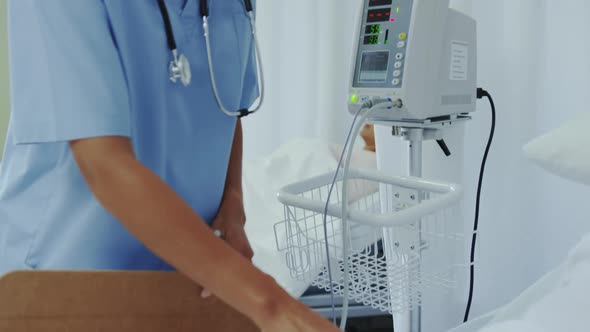 Side view of African american female doctor talking with female patient in ward at hospital 4k