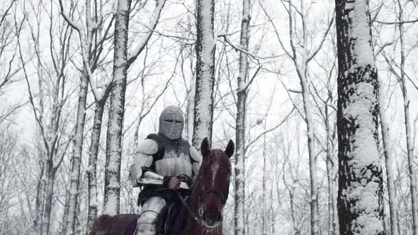 Portrait of Brave Medieval Knight Wearing Steel Protection and Helmet Being Horseback on Battlefield