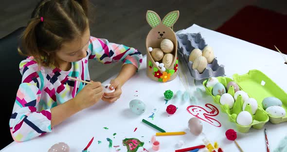 Happy Little Girl Painting Drawing with Brush Eggs at Home