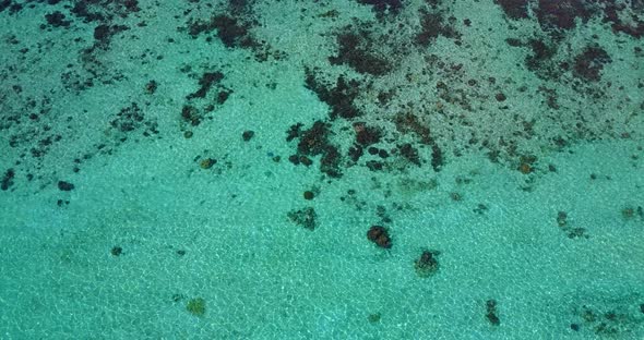 Daytime drone travel shot of a sunshine white sandy paradise beach and blue water background in best