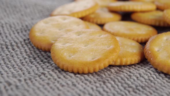 Round crispy crackers on a gray rough rustic jute cloth. Macro