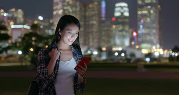 Woman use of mobile phone in city at night