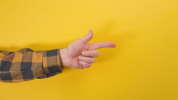 A man's hand in a shirt shows the direction of the index finger of the hand to the right side.