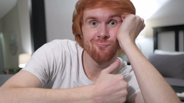 Thumbs Up By Casually Sitting Redhead Man Close Up