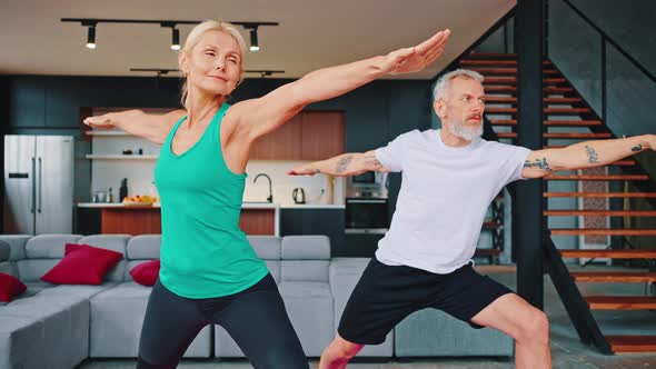 Close Up Adult Greyhaired Couple Practicing Yoga on the Living Room of Their Comfortable Modern