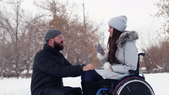 Disabled Woman is Having Fun and Happily Chatting with Boyfriend in Winter Park Side View