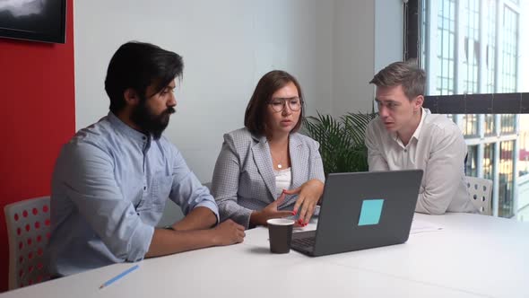 Tracking Shot of Multiethnic Business Team Brainstorming Using Laptop Computer in Meeting Room