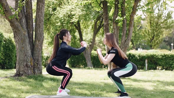 Two Pretty Young Women Are Training Outdoors at the Park