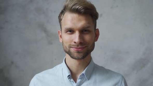 Confident Smiling Young Business Man Looking at Camera at Grey Wall Portrait