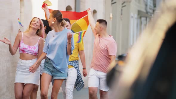 A smiling group of people waving rainbow flag for lgbt rights