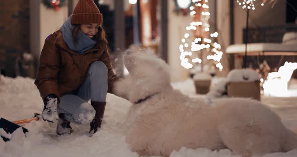 Woman Playing with Her Dog on the Backyard in Winter