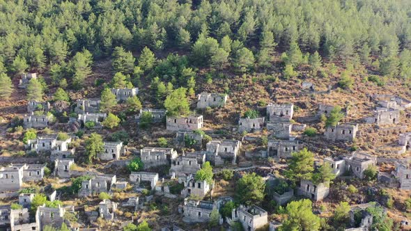 wide aerial shot panning around abandoned buildings in ruin at the famous greek village of kayakoy l