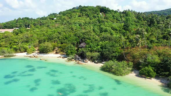 Idyllic vacation gateway on tropical island with lush vegetation and secret beaches washed by clear