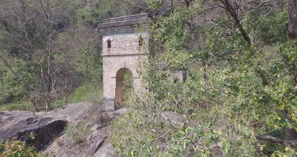 Old stone ruins hidden in the forest of Rishikesh, India, pan shot