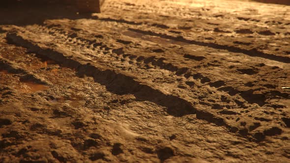 Excavator or digger at muddy construction site during sunset. Closeup on shovel.