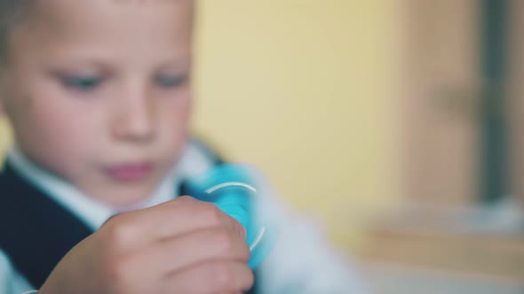 Funny Schoolkid Spends Time Playing with Spinner in Class