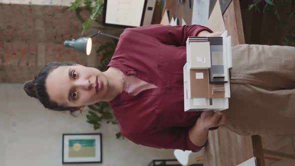 Vertical Portrait Of Female Architect With Paper House Layout