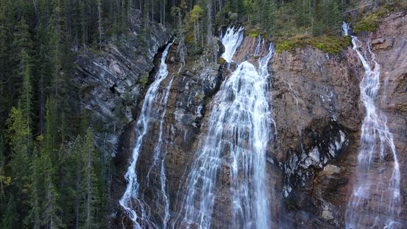 Short drone clip showing a waterfall and some trees in a natural landscape in Alberta, Canada. 4K ae