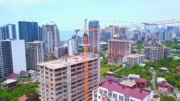 View from height of building under construction against background of sea city.