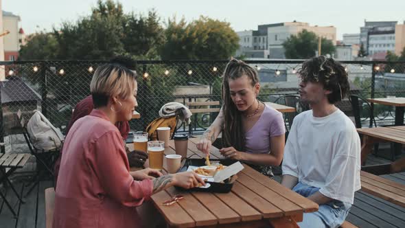 Friends Eating French Fries at Rooftop Bar