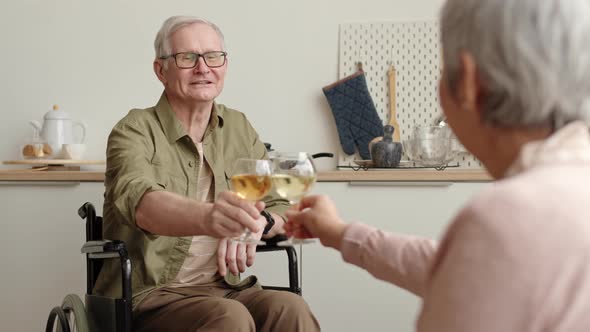 Man in Wheelchair Clinking Wine Glasses