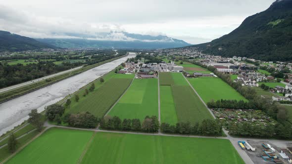 Liechtenstein with Houses on Green Fields in Alps Mountain Valley Aerial View