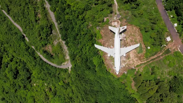 Top Shot White Airplane on Brown Earth in Green Tropical Bushes