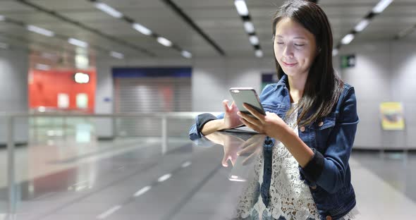 Woman using mobile phone in station