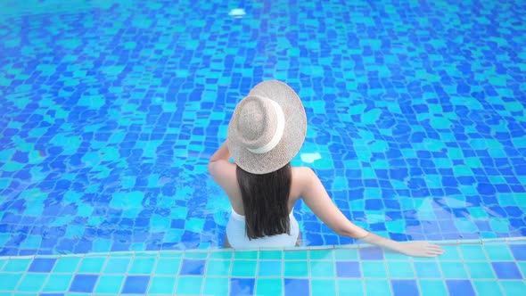 Young asian woman enjoy around outdoor swimming pool for leisure