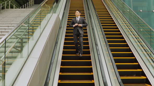 Japanese businessman taking the escalator