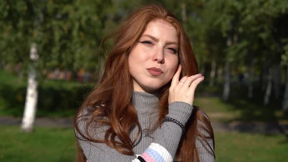 Smiling Redhead Outdoors Illuminated By Sun