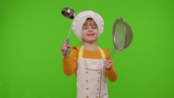 Funny Child Girl Cook Chef Baker in Apron and Hat Dancing with Sieve and Ladle Fooling Around