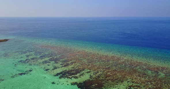 Natural birds eye clean view of a white paradise beach and aqua blue water background in colourful 4