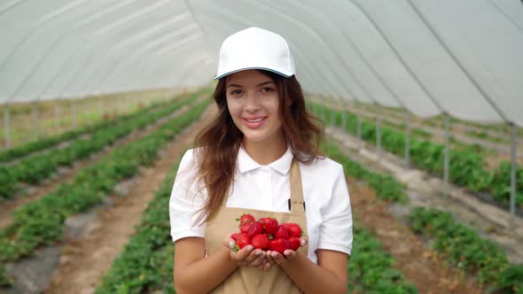 Smiling Woman Enjoying Good Harvest in Greenhouse