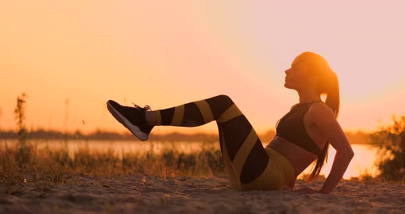 Strong Young Woman Doing a Medicine Ball Workout on Sand Dunes