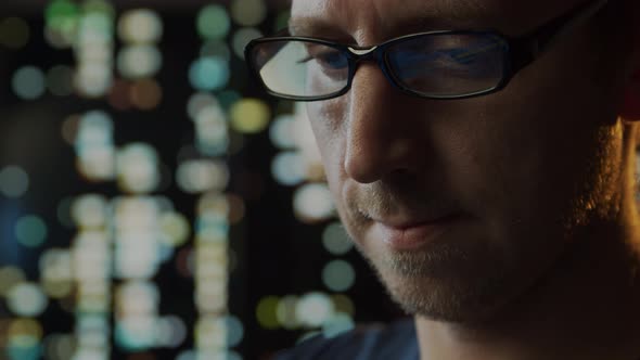 Close-up portrait of a young man working at the computer.