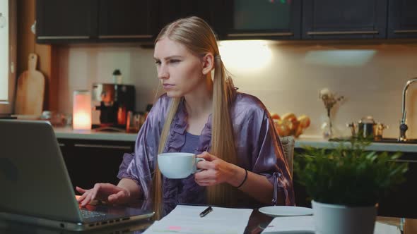 Working at Home: Busy Woman in Home Bathrobe Drinking a Cup of Coffee