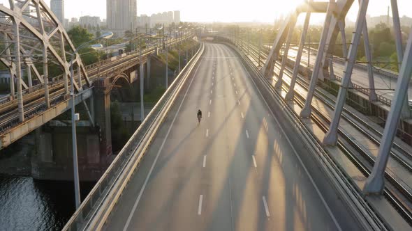 Aerial drone view of cyclist riding over the bridge