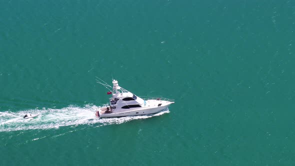 Beautiful tracking shot of Yacht in turquoise blue seas from top of Dukes Nose Track, Totara North,