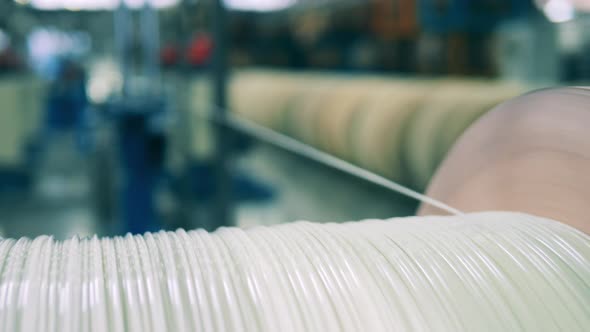 Thick Whitecolored Power Cable Unwinding From a Huge Spool in a Close Up