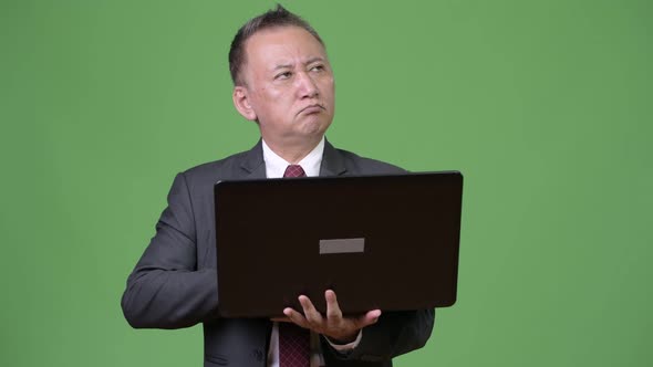 Mature Japanese Businessman Working with Laptop