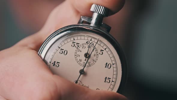 Stopwatch in Male Hand Counts Down Seconds