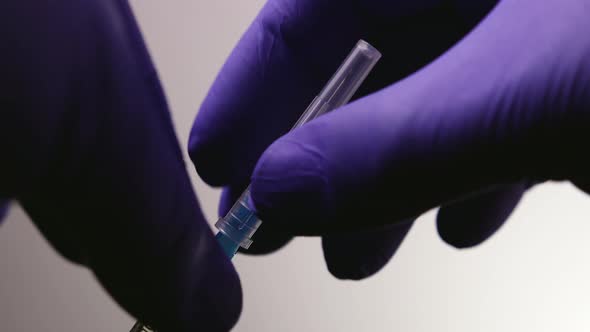 Doctor's Hands Remove the Protective Cap From the Needle on the Syringe