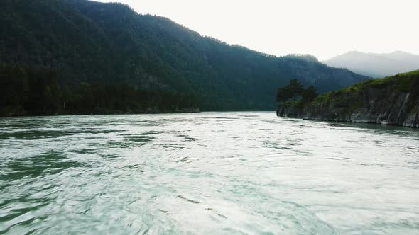 Flying Over the Water at High Speed Against the Backdrop of a Mountain Landscape