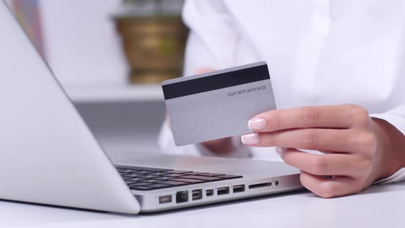 Woman Buying Online with a Silver Credit Card and Tablet. Close Up