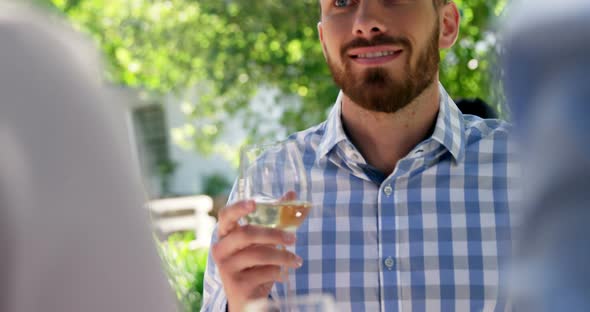 Man interacting with friends while having wine