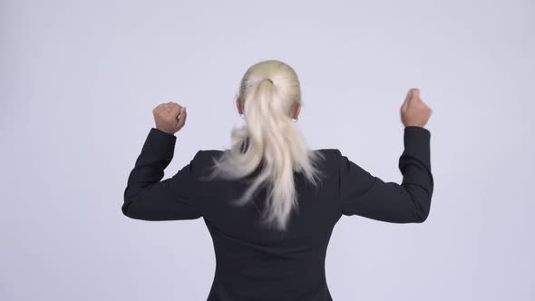 Rear View of Young Happy Blonde Businesswoman with Fists Raised