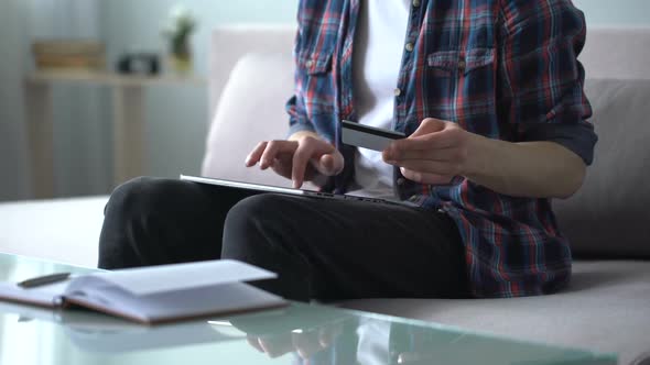 Man Entering Credit Card Data Into Tablet, Paying for Airline Ticket, Booking