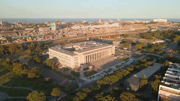 Aerial parallax shot of the Faculty of Law of University of Buenos Aires and Villa 31 at golden hour